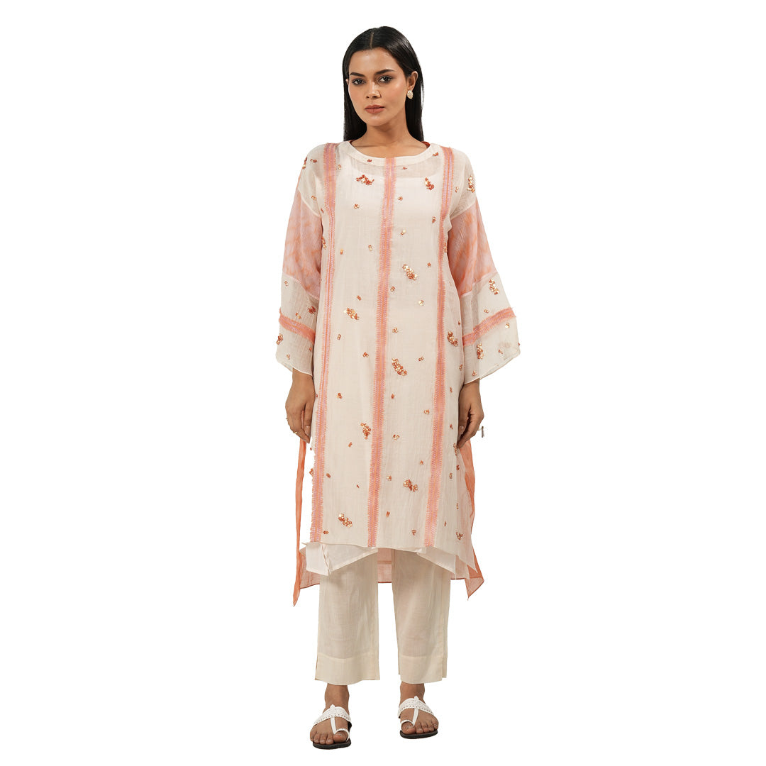 A women wearing Peach Colored Kurta Set with white pants.