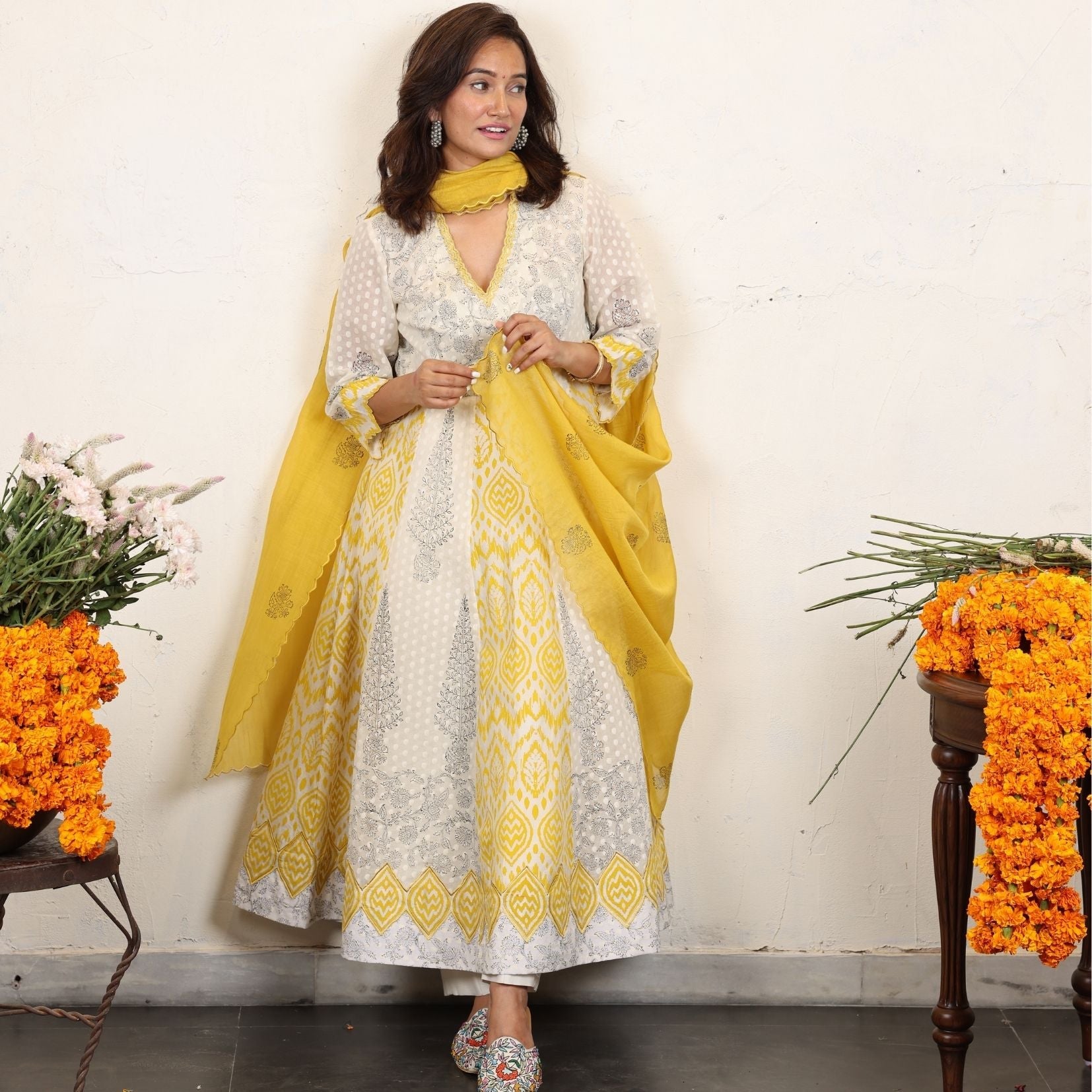 A women wearing white and yellow kurta set with Dupatta.