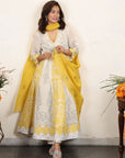 A women wearing white and yellow kurta set with Dupatta.