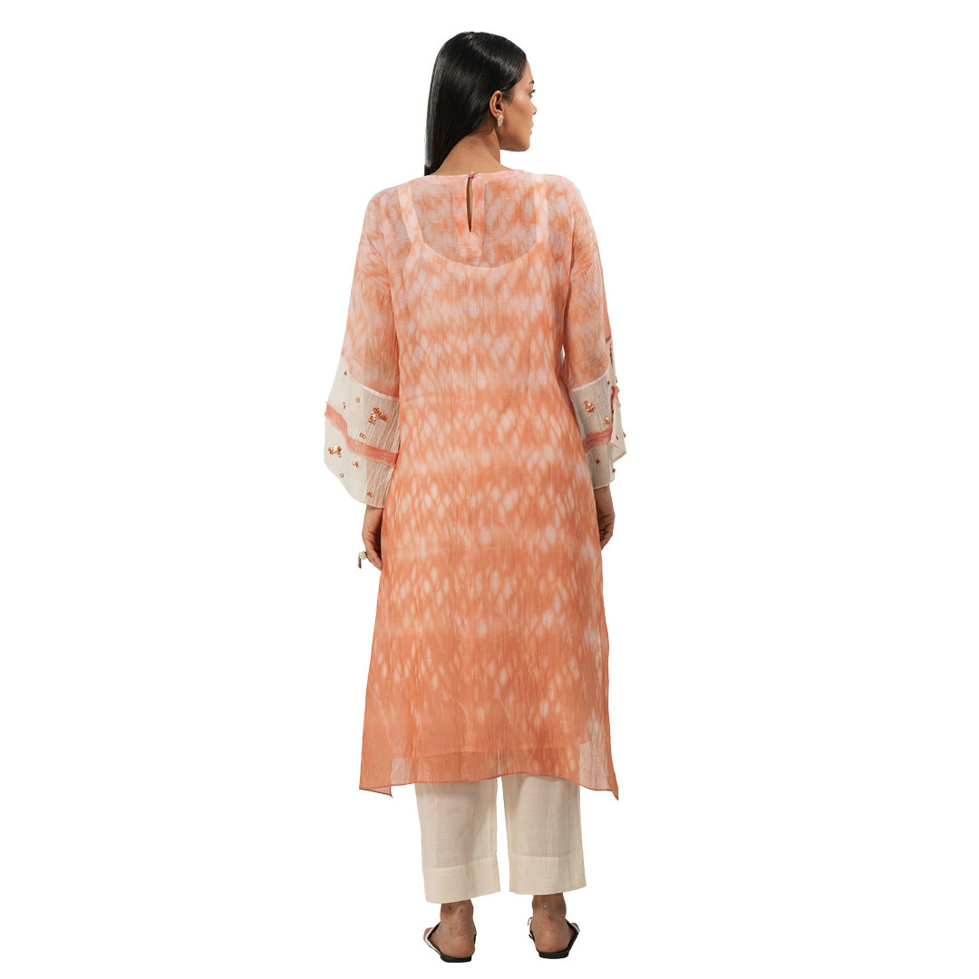 A women wearing Peach Colored Kurta Set with white pants.