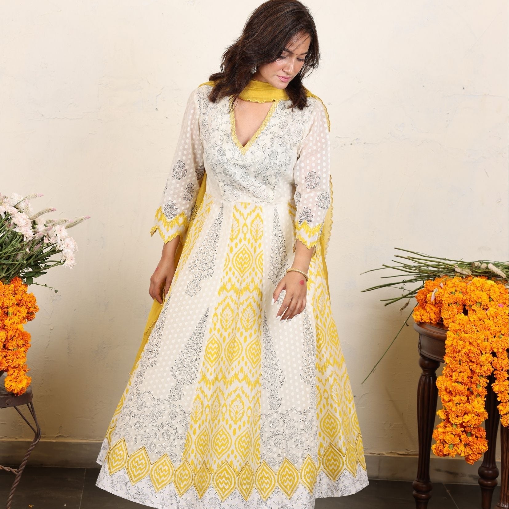 A women wearing white and yellow kurta set with Dupatta.