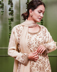 A women wearing beige colored Sharara Suit Set with Dupatta.