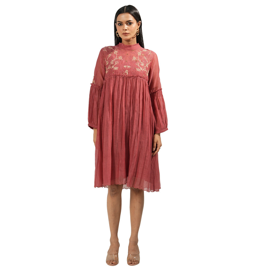 A women wearing maroon colored full sleeves dress with knee length.