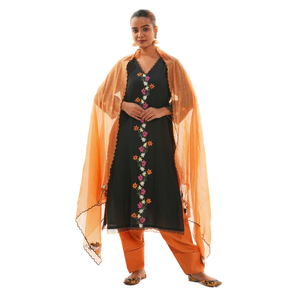 A women wearing black colored kurta set with orange colored pants and dupatta.