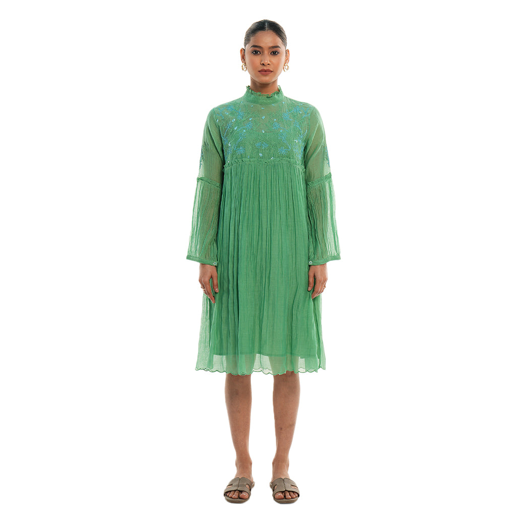 A women wearing green colored full sleeves designer dress with knee length.