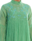 A women wearing green colored full sleeves designer dress.