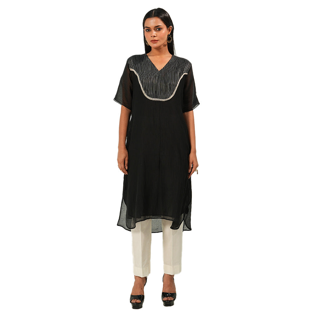 A women wearing Black Kurta Set with White Pants.