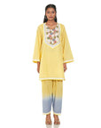 A women wearing yellow colored kurta set with yellow and blue pants.