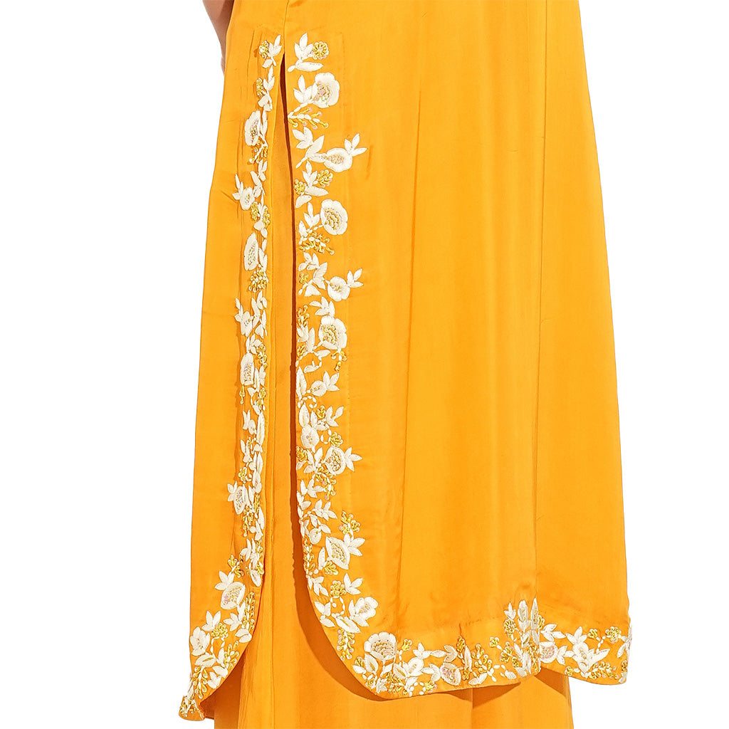 A women wearing stylish whole orange kurta set with palazzo and dupatta.