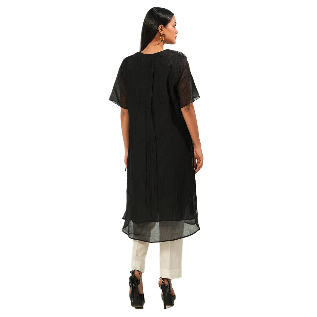 A women wearing Black Kurta Set with White Pants.