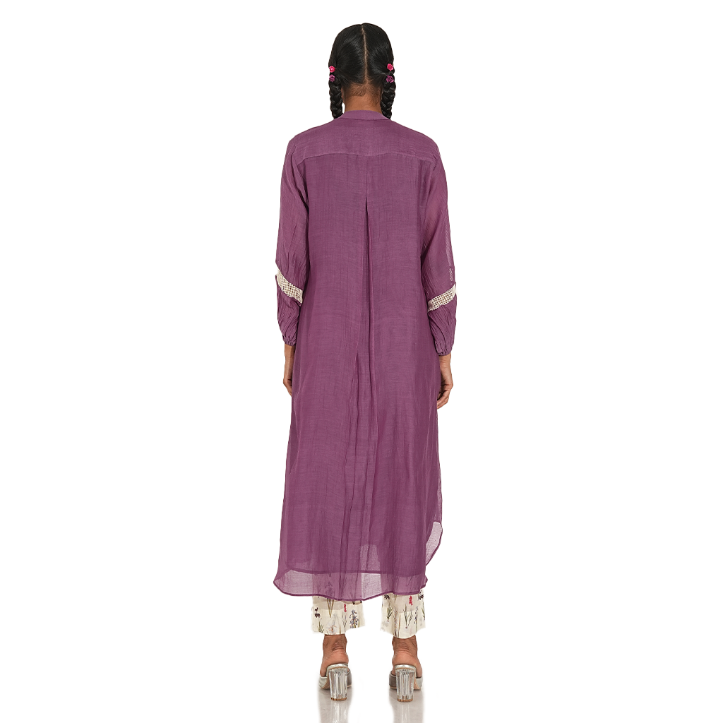 A woman wearing Purple Colored Kurta Set with White Printed Pants.