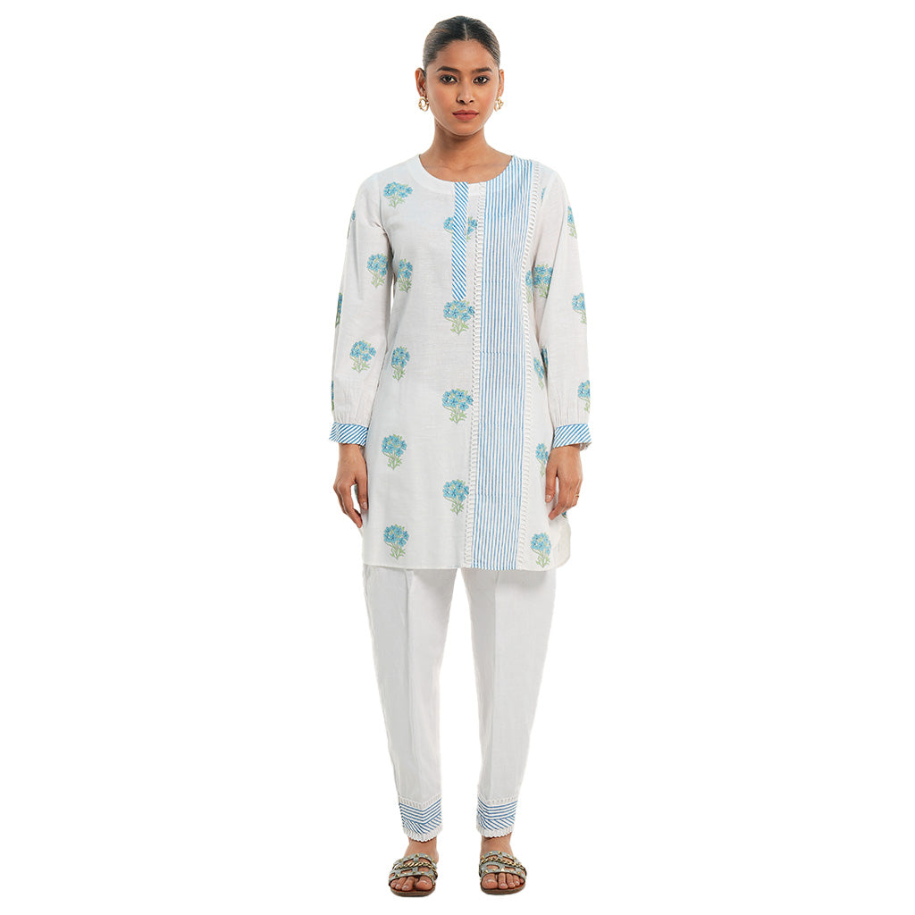 A women wearing White Kurta Set with blue colored floral print on it.