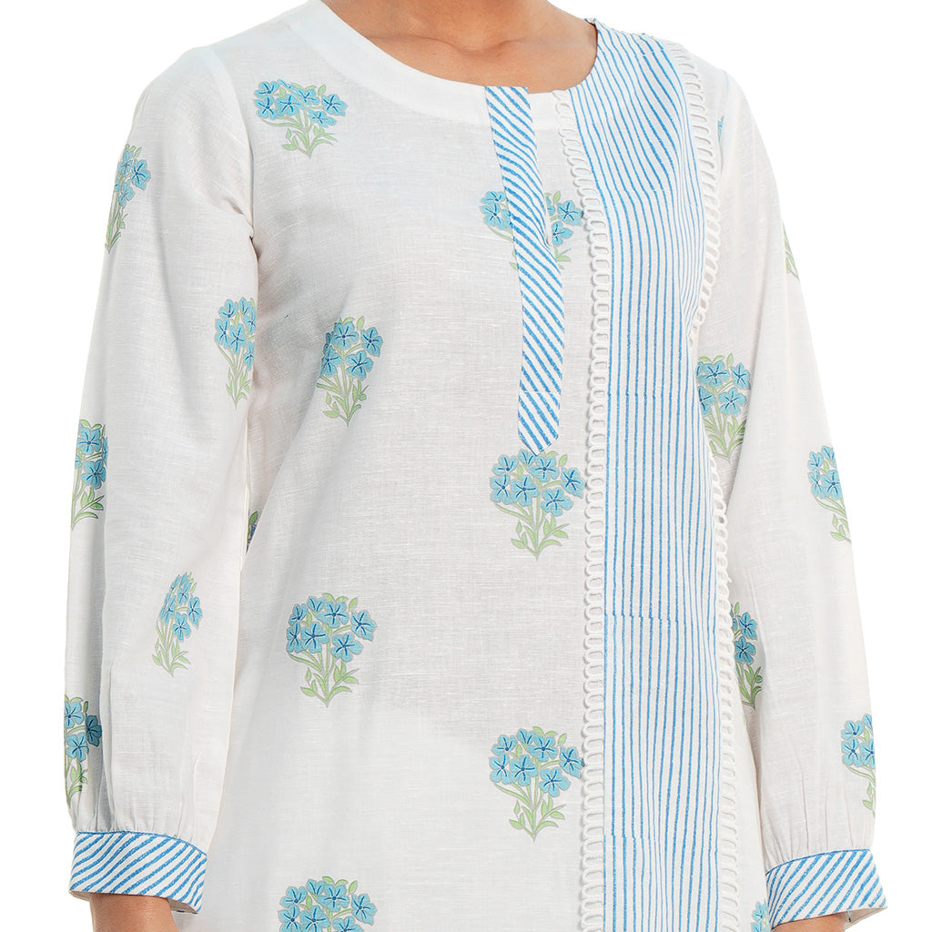 A women wearing White Kurta Set with blue colored floral print on it.