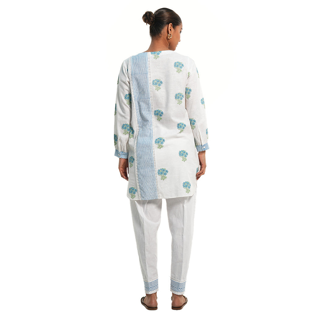 A women wearing White Kurta Set with blue colored floral print on it.