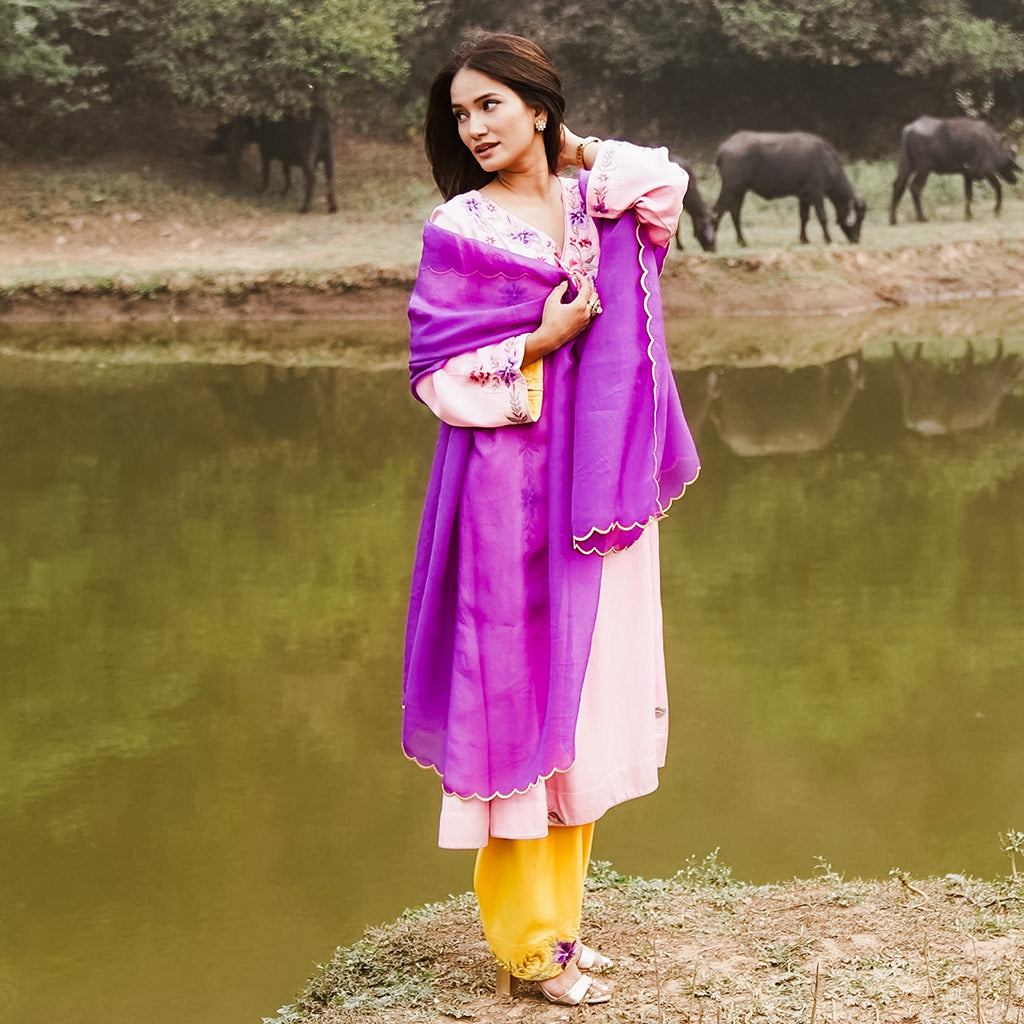 A woman wearing Purple and Blue Kurta Set with Yellow Colored Pants and Dupatta.