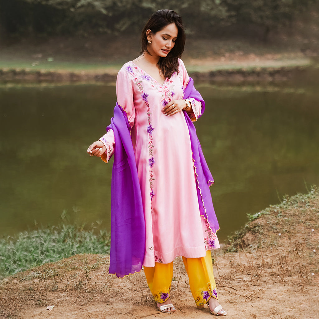 A woman wearing Purple and Blue Kurta Set with Yellow Colored Pants and Dupatta.