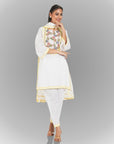 A women wearing white colored kurta set with dupatta with flowery design in it.