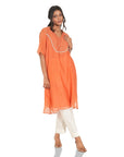 A women wearing Orange Kurta Set with White Pants.