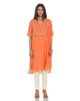 A women wearing Orange Kurta Set with White Pants.