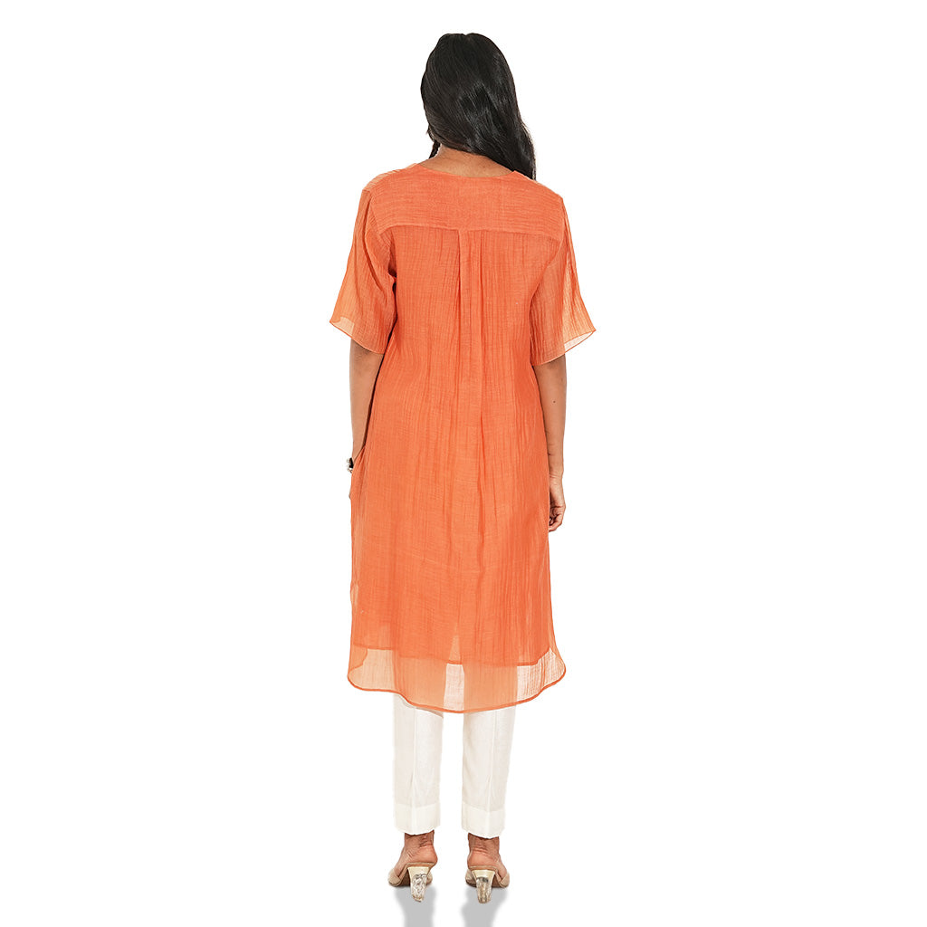 A women wearing Orange Kurta Set with White Pants.